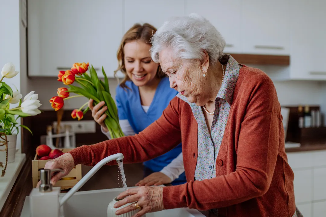 Carer and elderly woman with flowers